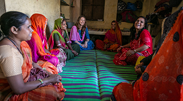 A group of women sit in a circle having a discussion