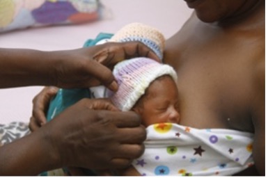 Doctor tending to a newborn being held by mother