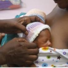 Doctor tending to a newborn being held by mother